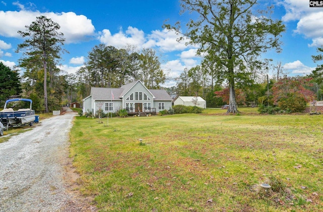 view of front of property with gravel driveway and a front lawn