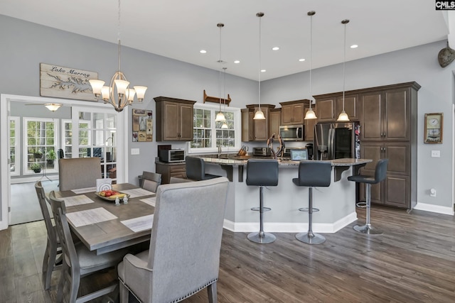 dining area featuring a high ceiling, dark wood-style flooring, recessed lighting, and a toaster