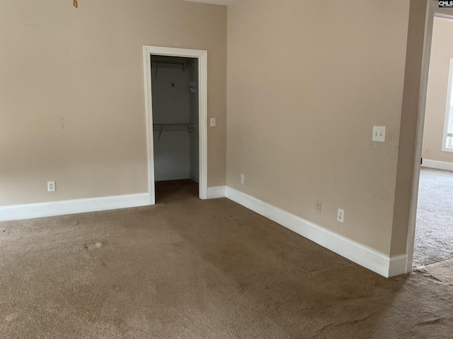 spare room featuring carpet floors and baseboards