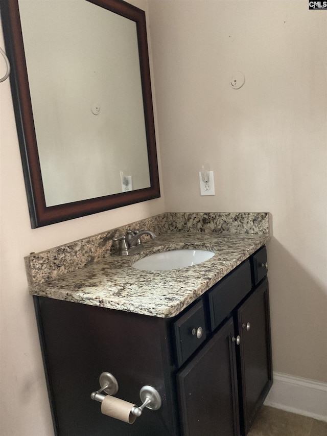 bathroom with vanity, baseboards, and tile patterned floors