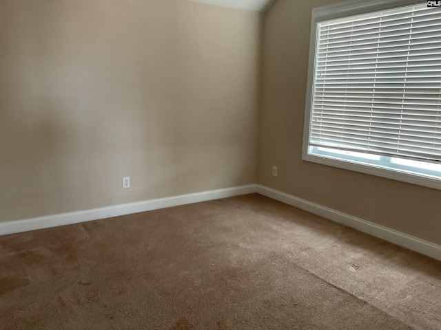 spare room featuring carpet flooring and baseboards