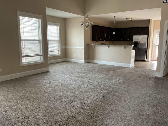 kitchen with open floor plan, stainless steel appliances, baseboards, and a kitchen breakfast bar