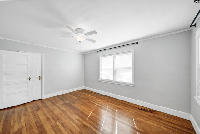 unfurnished room featuring hardwood / wood-style flooring, baseboards, and crown molding