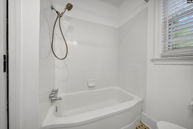 full bath with toilet, baseboards, and shower / bathtub combination