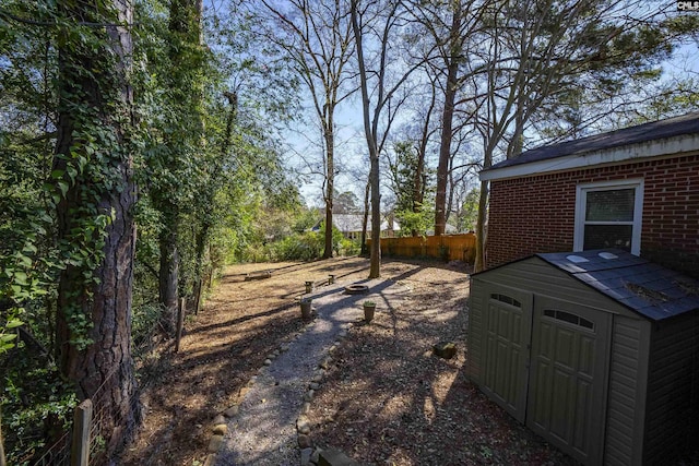 view of yard featuring a shed, an outdoor structure, and fence