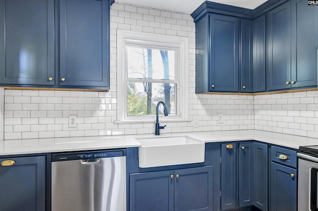 kitchen with blue cabinetry, tasteful backsplash, appliances with stainless steel finishes, and a sink