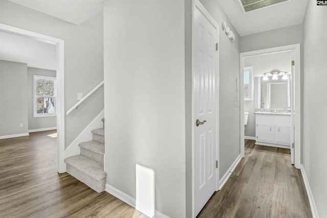 hall featuring stairway, wood finished floors, and baseboards