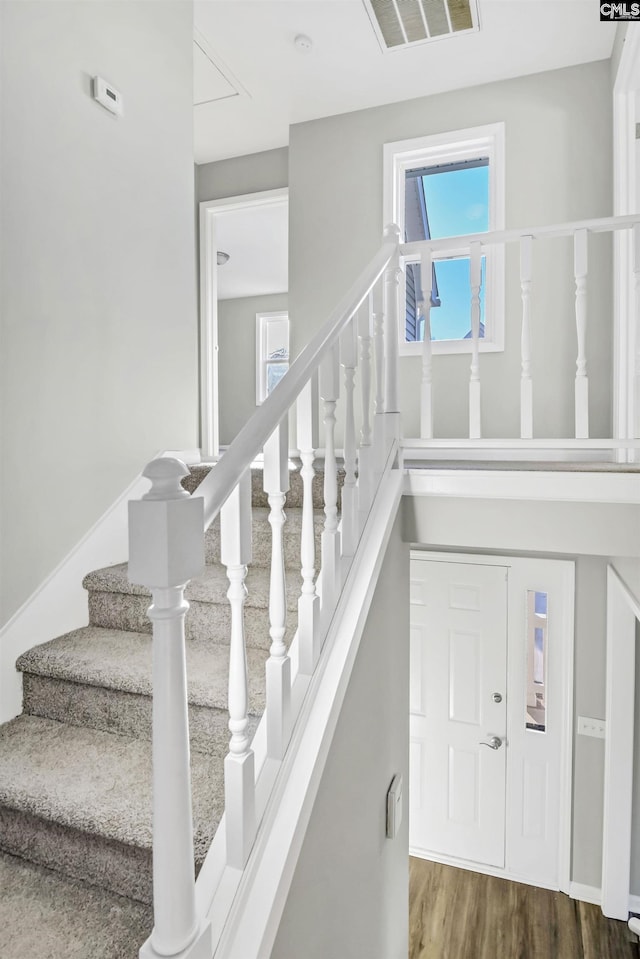 stairs featuring wood finished floors and visible vents