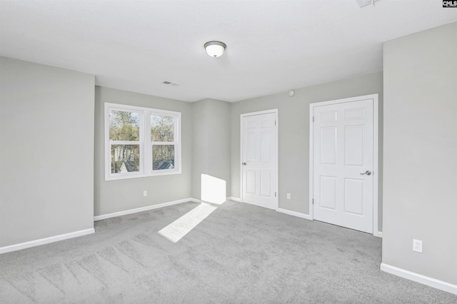 unfurnished bedroom featuring carpet, visible vents, and baseboards