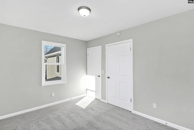 unfurnished bedroom featuring carpet floors and baseboards