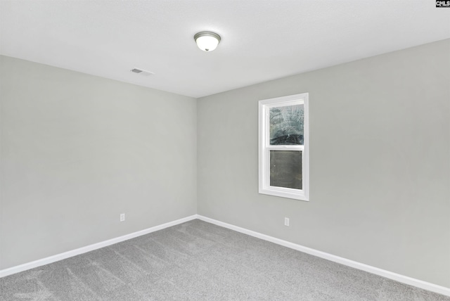 unfurnished room featuring carpet and baseboards