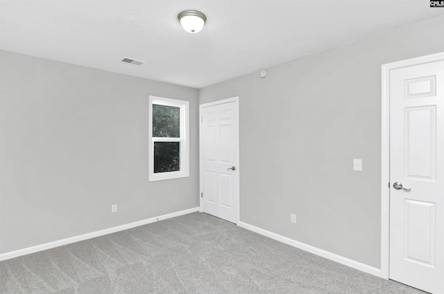 unfurnished room featuring carpet, visible vents, and baseboards