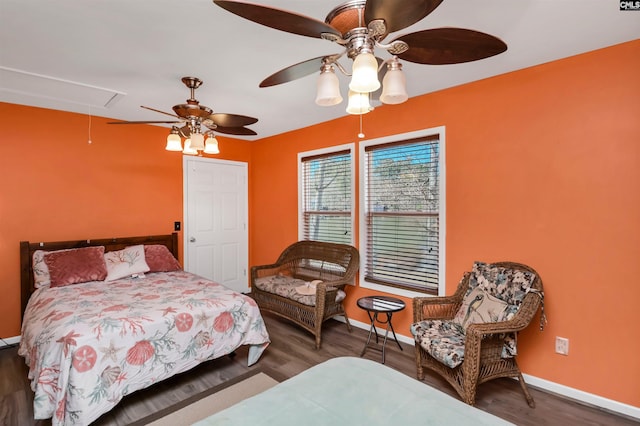 bedroom with wood finished floors, attic access, and baseboards