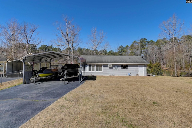 view of front facade with aphalt driveway, a detached carport, and a front lawn