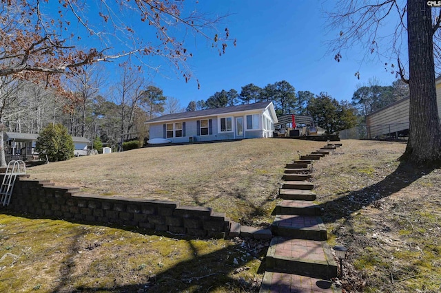 single story home featuring stairway and a front lawn