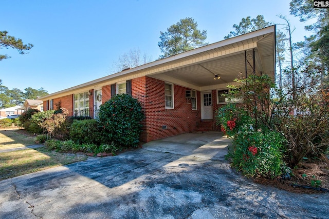 single story home with a carport, brick siding, and driveway