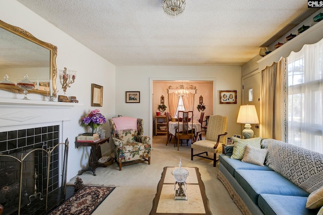 living area featuring light carpet, a textured ceiling, a tile fireplace, and a healthy amount of sunlight