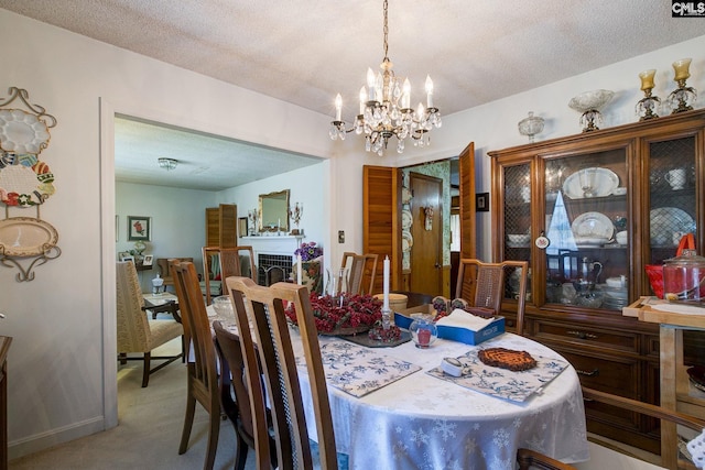 dining room with a textured ceiling, a fireplace, and light colored carpet