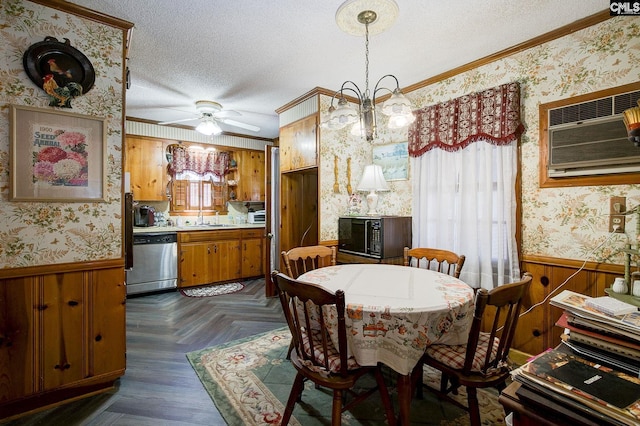 dining room with a wainscoted wall, crown molding, a textured ceiling, and wallpapered walls