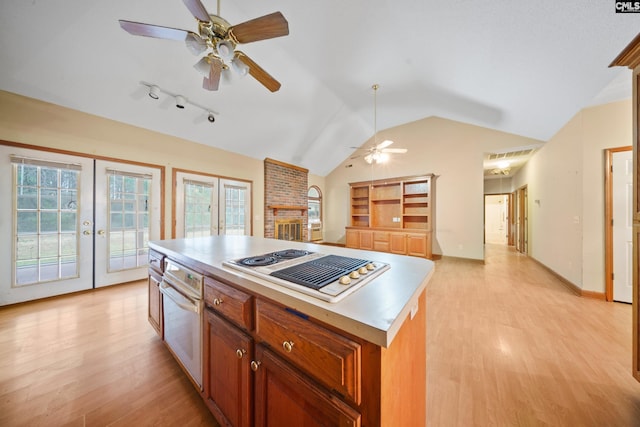 kitchen with stovetop with downdraft, lofted ceiling, french doors, and light wood-type flooring