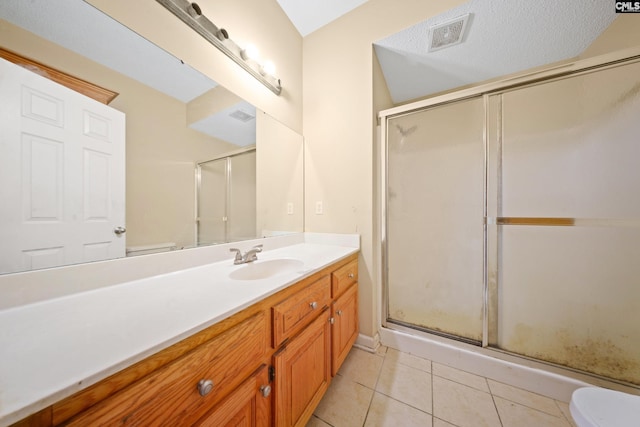 full bath with toilet, visible vents, vanity, a shower stall, and tile patterned floors