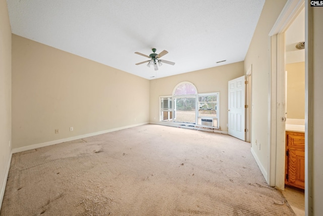 spare room featuring baseboards, a textured ceiling, a ceiling fan, and light colored carpet