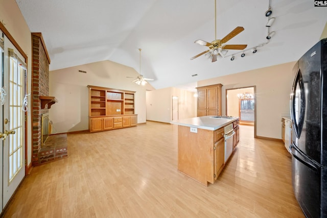 kitchen featuring a ceiling fan, freestanding refrigerator, light countertops, light wood-type flooring, and a fireplace