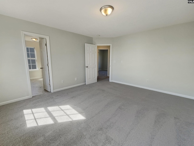 unfurnished bedroom with carpet, ensuite bath, and baseboards