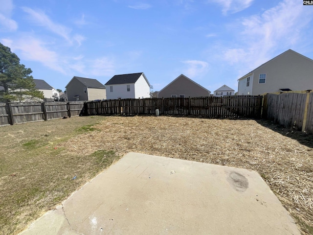 view of yard featuring a patio area, a fenced backyard, and a residential view