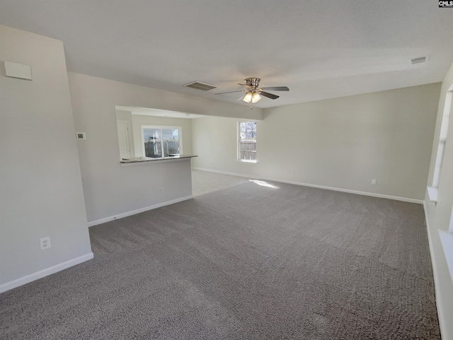 spare room with carpet floors, visible vents, and baseboards