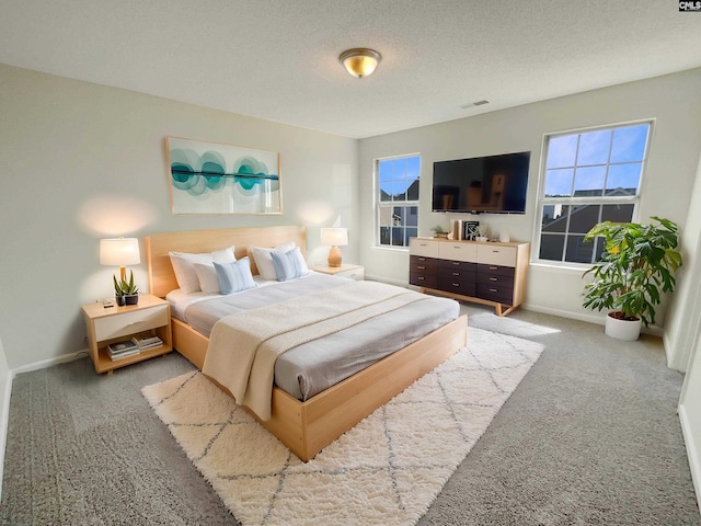 bedroom with baseboards, visible vents, a textured ceiling, and light colored carpet