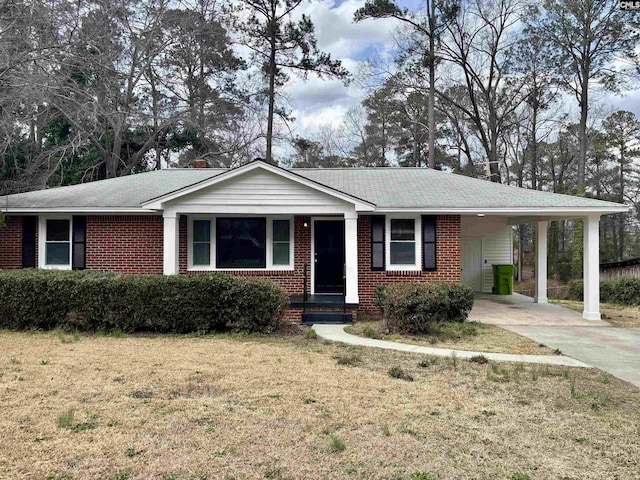 ranch-style house with driveway, brick siding, a carport, and a front yard