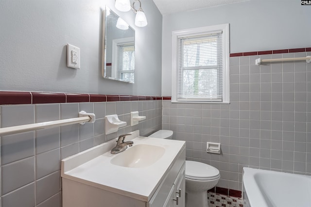 full bath with a wainscoted wall, vanity, toilet, and tile walls