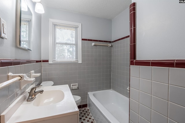 full bathroom with toilet, shower / bathtub combination, a textured ceiling, vanity, and tile walls