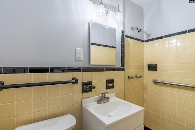 bathroom featuring vanity, toilet, and tile walls