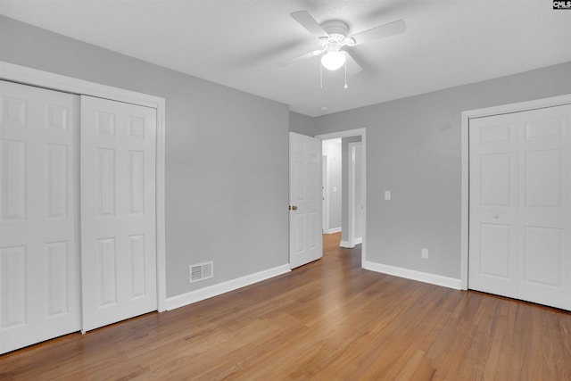 unfurnished bedroom featuring visible vents, baseboards, ceiling fan, a textured ceiling, and light wood-type flooring