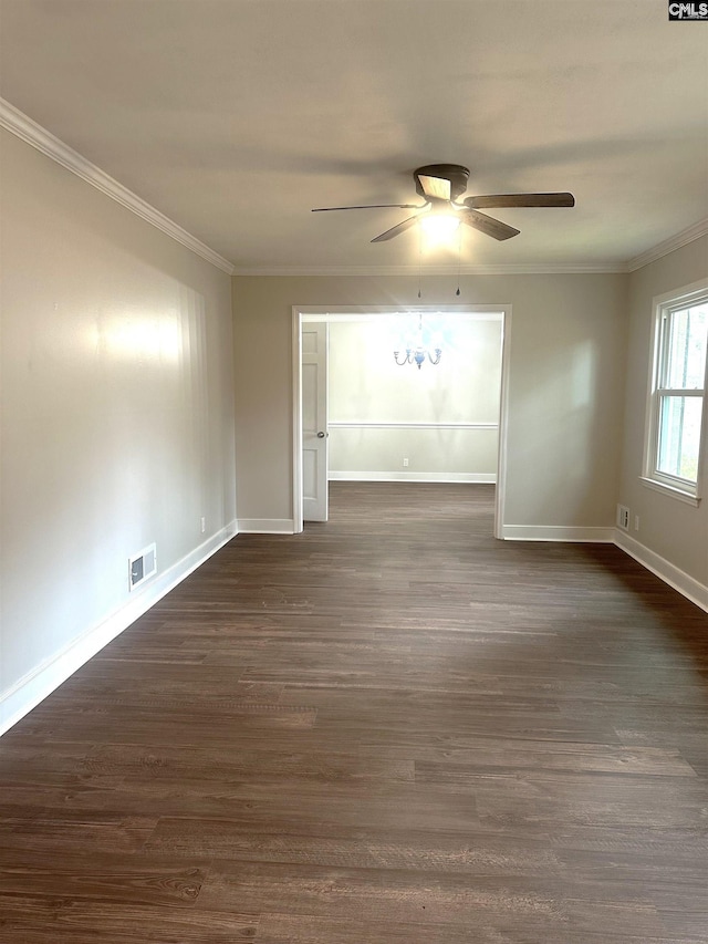 spare room featuring dark wood finished floors, visible vents, crown molding, and baseboards