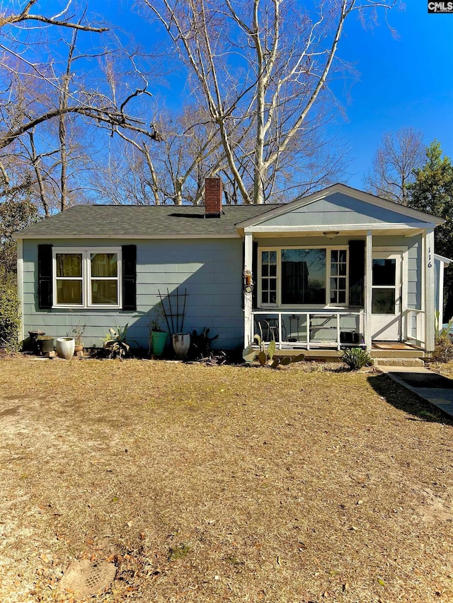 view of front of home with covered porch and a chimney