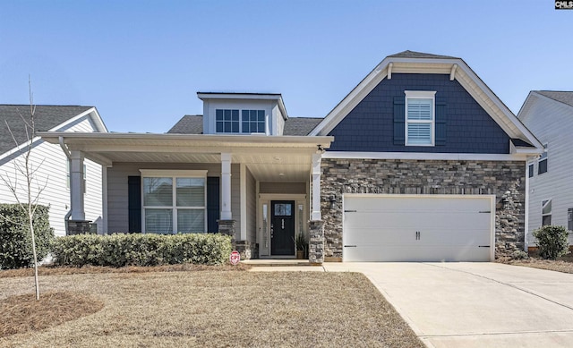 craftsman-style house with a garage, stone siding, and driveway