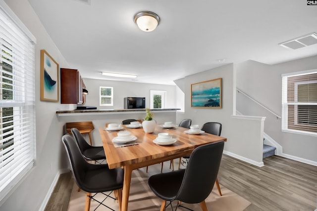 dining room featuring visible vents, baseboards, and wood finished floors