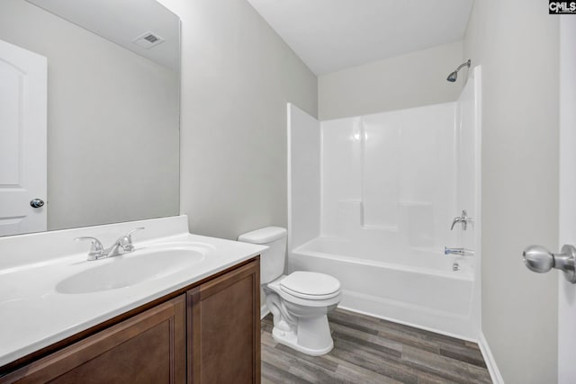 bathroom with bathing tub / shower combination, visible vents, toilet, vanity, and wood finished floors