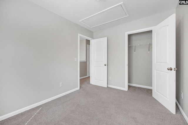 unfurnished bedroom featuring attic access, carpet, and baseboards