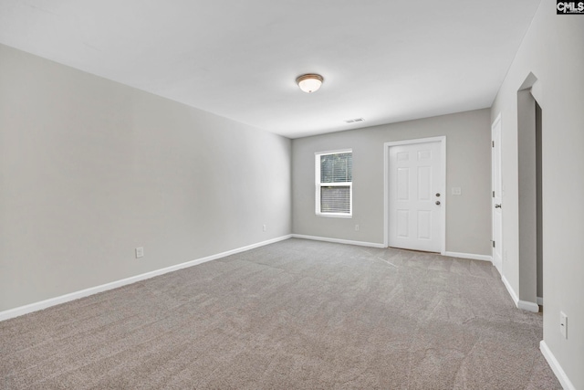 empty room featuring carpet, visible vents, and baseboards