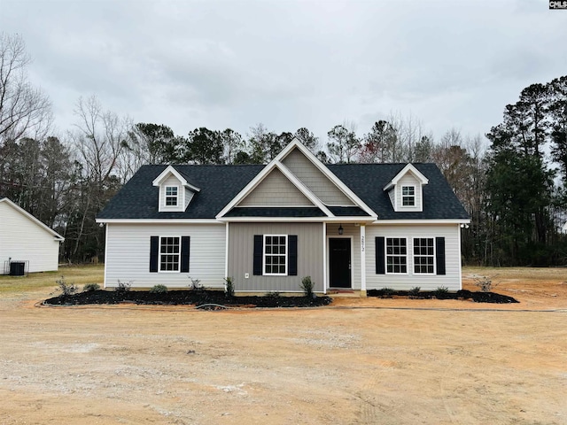 view of front of home with central AC unit and a shingled roof