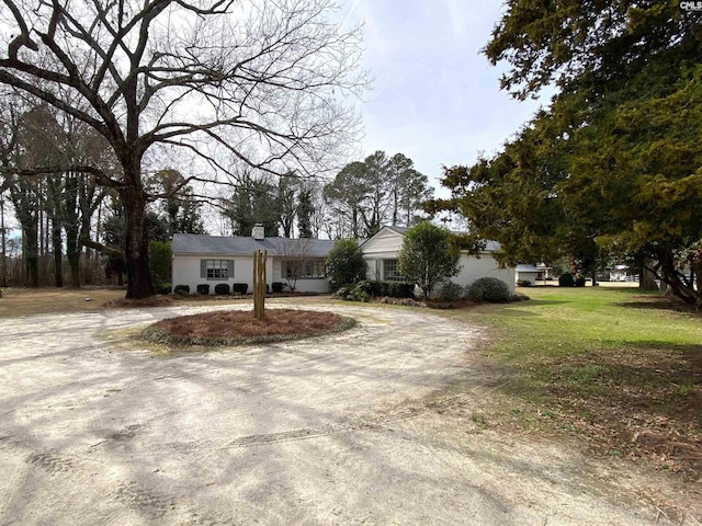 single story home featuring driveway and a front lawn