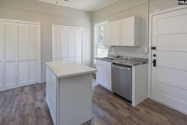 kitchen with stainless steel dishwasher, a kitchen island, a sink, and dark wood finished floors