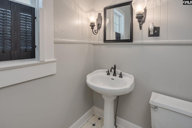 half bath with toilet and baseboards