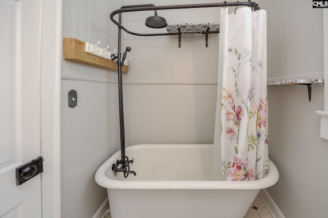 full bathroom featuring curtained shower, baseboards, and a washtub