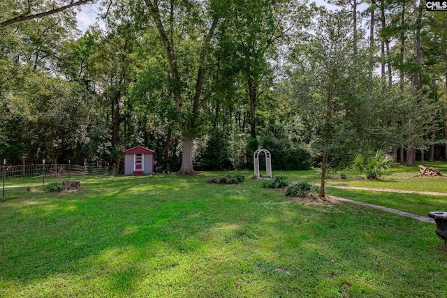 view of yard with an outbuilding, a shed, and fence