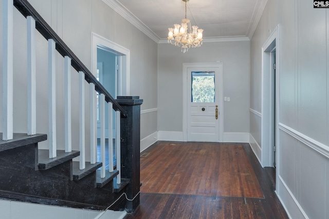 entrance foyer featuring hardwood / wood-style flooring, baseboards, ornamental molding, stairway, and an inviting chandelier